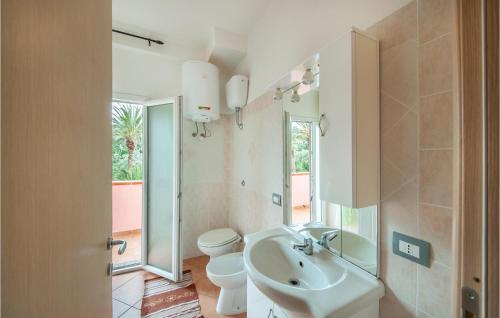 bagno con lavandino, servizi igienici e specchio di Stunning Apartment In La Maddalena With House A Panoramic View a La Maddalena
