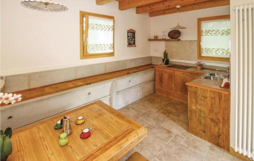 una cucina con tavolo in legno e lavandino di Awesome Home In Belluno Bl With Wifi a Lèvego