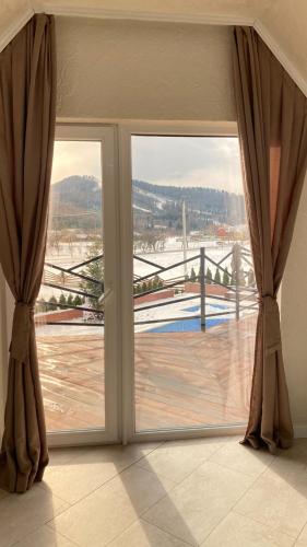 a sliding glass door with a view of a balcony at Four Seasons In Carpathians in Migovo