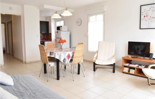 une cuisine et une salle à manger avec une table et des chaises dans l'établissement Amazing Apartment In Hauteville-Sur-Mer, à Hauteville-sur-Mer