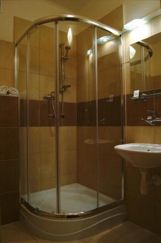 a shower with a glass door next to a sink at HotelsLublin in Lublin