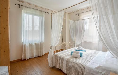 una camera da letto con un letto con lenzuola bianche e una finestra di Flora House 1 a Macerino