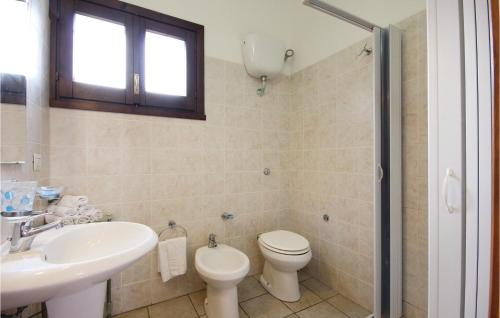 een badkamer met een toilet, een wastafel en een spiegel bij Beautiful Apartment In Costa Rei -ca- With Wifi in Monte Nai