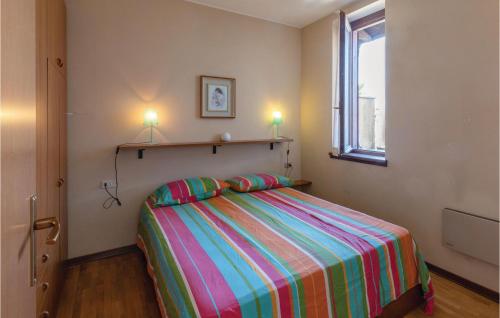 ein Schlafzimmer mit einem Bett mit einer bunten gestreiften Decke in der Unterkunft Over The Blue in Germignaga
