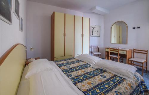 イスキアにあるAmazing Apartment In Santangelo Dischia With 1 Bedrooms And Wifiのベッドルーム1室(ベッド2台、テーブル、鏡付)