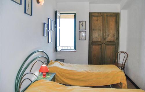 サン・ジョルジョにあるAwesome Apartment In Gioiosa Marea Me With 2 Bedrooms And Outdoor Swimming Poolのベッドルーム1室(ベッド2台付)、窓、ドアが備わります。