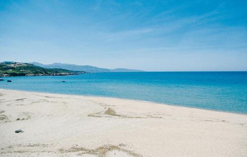 une plage de sable avec l'océan en arrière-plan dans l'établissement Holiday Home Sagone Xlvii, à Sagone