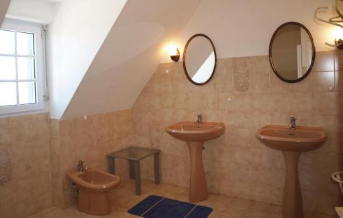 een badkamer met 2 wastafels en 2 spiegels bij 5 Bedroom Nice Home In Kerlouan in Kerlouan