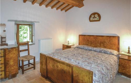 een slaapkamer met een bed, een stoel en een raam bij Agriturismo La Ginestra in Lama