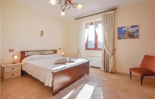 a bedroom with a bed and a chair and a window at Villa Aquaro in Ogliastro Cilento
