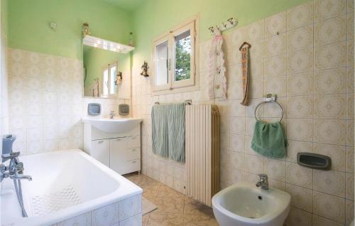 y baño con bañera, lavabo y espejo. en Amazing Home In Astracaccio Lu With 2 Bedrooms, en Cocciglia