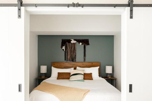 a bedroom with a large white bed with green walls at Colorful Western Vibe - Pet-Friendly - Zuni Lofts in Denver