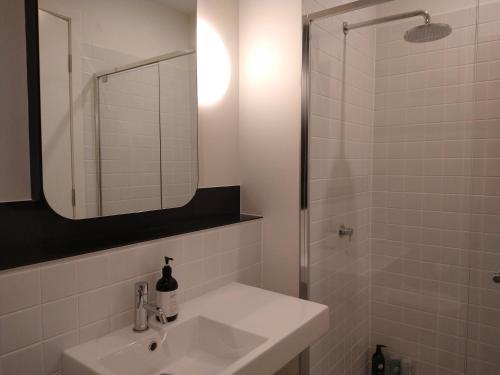 a white bathroom with a sink and a shower at Brand New Spacious Woden Apartment - KingBed&WiFi in Phillip