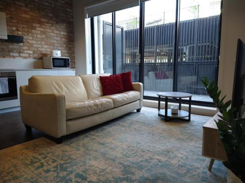 sala de estar con sofá y mesa en Brand New Spacious Woden Apartment - KingBed&WiFi, en Phillip