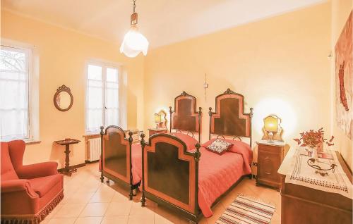 una camera con un grande letto e una sedia rossa di La Locanda a Portacomaro