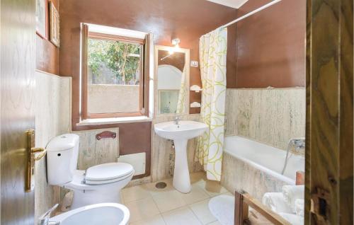 een badkamer met een toilet, een wastafel en een bad bij Casa Stranges in Copanello