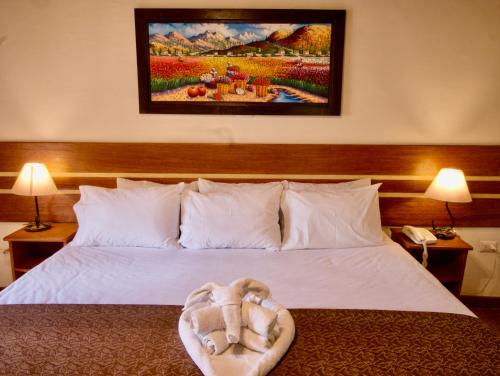 a bed with a stuffed animal on top of it at Sol Ollantay Boutique Hotel in Ollantaytambo
