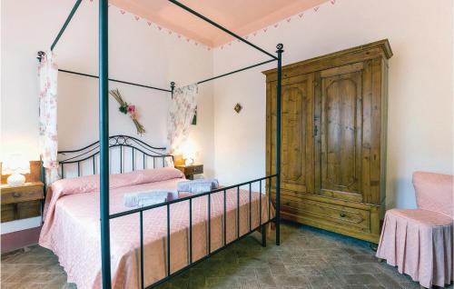 1 dormitorio con cama con dosel y silla en Monterufoli 2m, en Pomarance