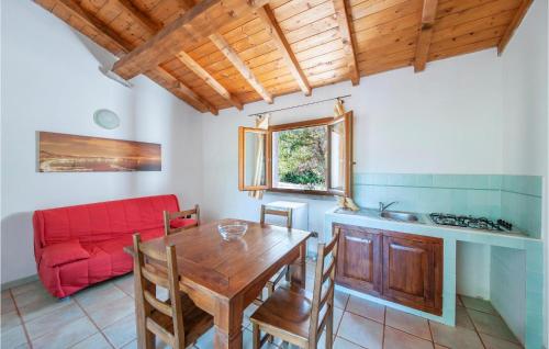 a kitchen with a wooden table and a red couch at Ginepri Bilo in Badesi