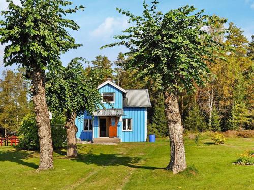 a blue house in a yard with two trees at 4 person holiday home in ED-By Traum in Ed