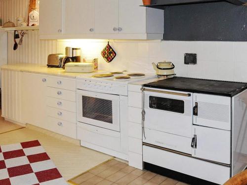 a kitchen with a white stove top oven next to a counter at 4 person holiday home in ED-By Traum in Ed