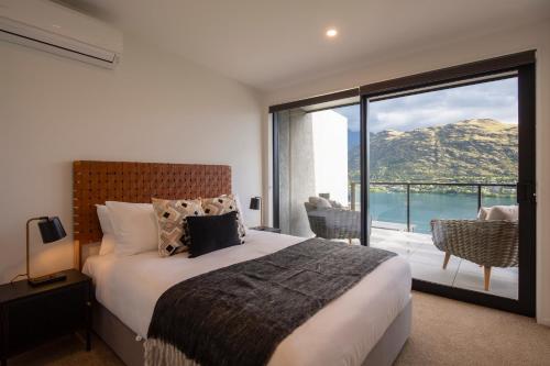 1 dormitorio con cama y vistas al océano en 4 Bedroom Home with elevated views of Lake Wakatipu & The Remarkables, en Queenstown