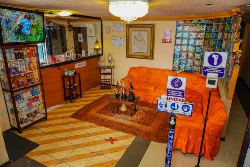 - un salon avec un canapé orange dans un magasin dans l'établissement Hotel Los Ilinizas, à Latacunga