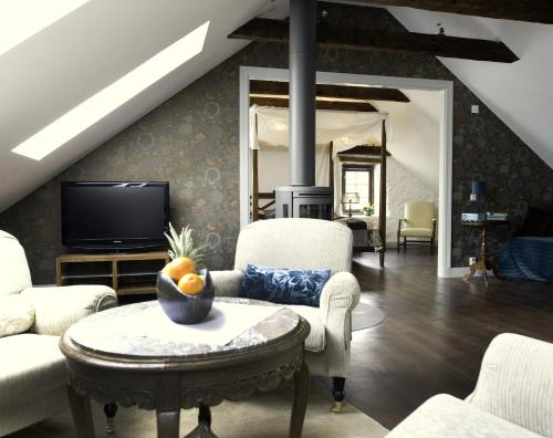 ein Wohnzimmer mit einem Sofa und einem TV in der Unterkunft Smakrike Krog & Logi in Ljugarn