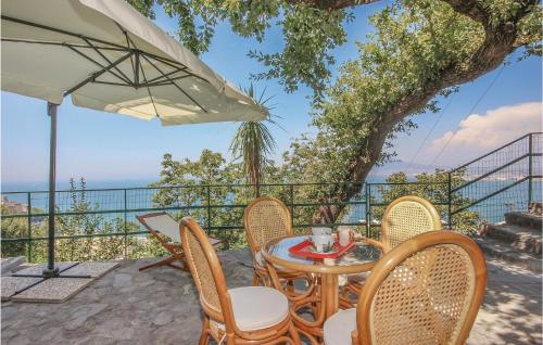 Un patio con una mesa y sillas y una sombrilla. en Casa Maria Elena, en Castellammare di Stabia