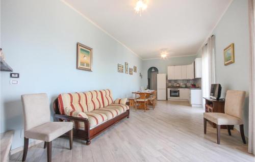 Una sala de estar con un sofá y sillas y una cocina. en Casa Maria Elena, en Castellammare di Stabia