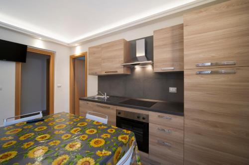 una cocina con armarios de madera y una cama en una habitación en Residence Tabor, en Bardonecchia