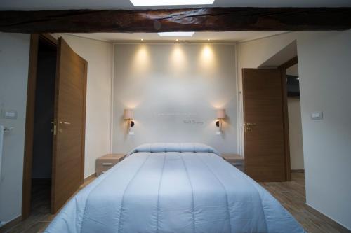 ein großes Bett in einem Zimmer mit zwei Lichtern an der Wand in der Unterkunft Residence Tabor in Bardonecchia