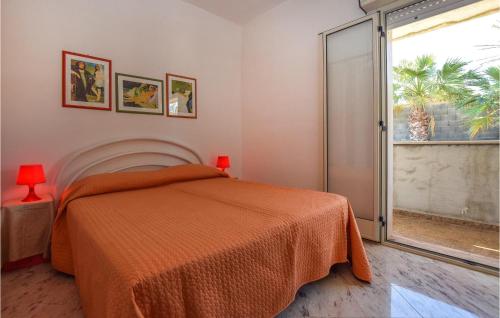 - une chambre avec un lit et une couverture orange dans l'établissement Villa Tot, à Santa Croce Camerina