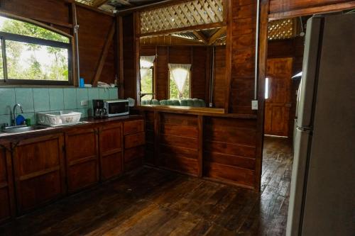 a kitchen with wooden cabinets and a counter top at Princesa de la Luna Ecolodge in Fortuna