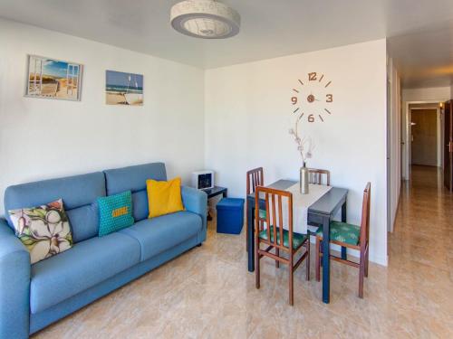 a living room with a blue couch and a table at Belvilla by OYO Apartment in Lloret de Mar in Lloret de Mar