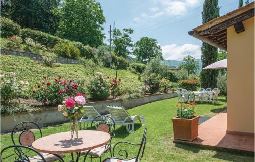 a patio with a table and chairs and flowers at Villino Le Rose in Dicomano