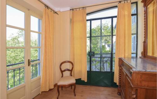 a room with a chair and large windows at Il Fienile in Portacomaro