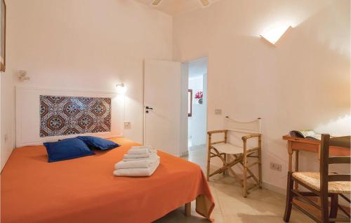 サン・ヴィート・ロ・カーポにあるLa Calettaのベッドルーム1室(オレンジ色のベッド1台、タオル付)