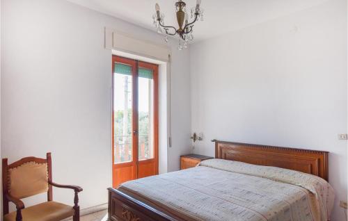 una camera con un letto e una sedia e una finestra di 2 Bedroom Amazing Apartment In Sellia Marina a Sellia Marina