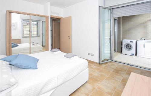 a bedroom with a large white bed and a washing machine at Lovely Apartment In Anzio With Kitchen in Anzio