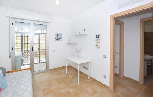 een witte kamer met een tafel en een raam bij Lovely Apartment In Anzio With Kitchen in Anzio