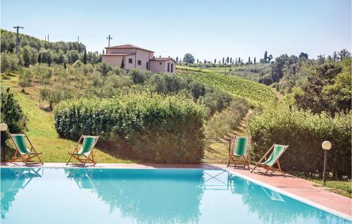 a swimming pool with three chairs and a house at Casale Del Borgo 7 in Querce