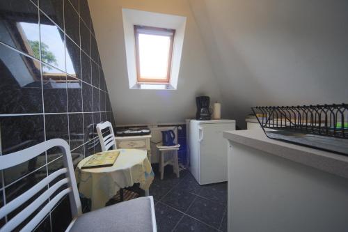 eine kleine Küche mit einem Tisch und einem kleinen Kühlschrank in der Unterkunft Apartament Leśmiana in Świnoujście