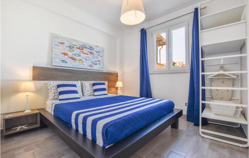 ein Schlafzimmer mit einem Bett mit blau-weißer Bettwäsche in der Unterkunft 2 Bedroom Amazing Apartment In Trappeto in Trappeto
