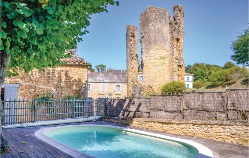 une piscine en face d'un bâtiment avec une clôture dans l'établissement Lovely Home In Sainte Alvère With Sauna, à Saint-Alvère