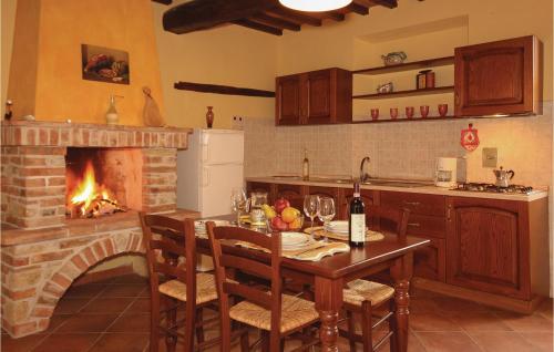 a kitchen with a table and a brick fireplace at Casale Del Borgo 12 in Querce