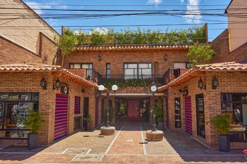 un edificio in mattoni con cortile con piante di Casa Rosé Hotel a Carmen de Viboral