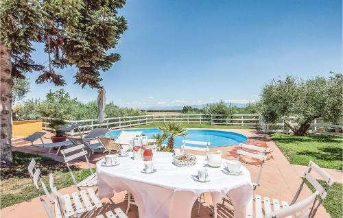 Biały stół z krzesłami i basen w obiekcie Beautiful Home In Roma w mieście La Storta