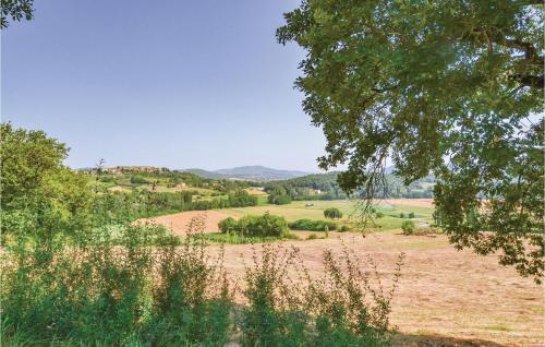 a field with trees and a hill in the distance at Borgo Lugnano in Lugnano