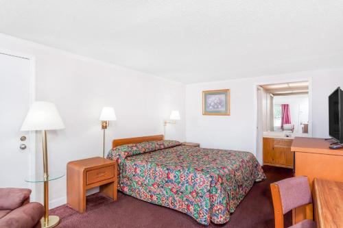 a hotel room with a bed and a television at Corbin Inn in Corbin